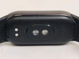 the back of a black apple watch sitting on top of a white table