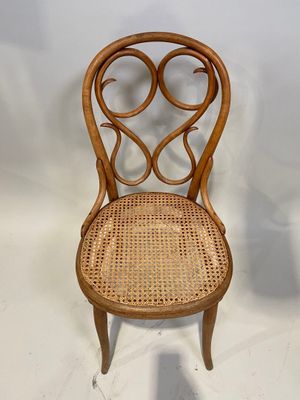 une image représentant une chaise en bois avec une assise en osier sur fond blanc