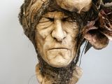 une sculpture représentant un homme avec une fleur sur la tête