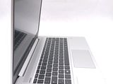 a silver laptop computer sitting on a white surface