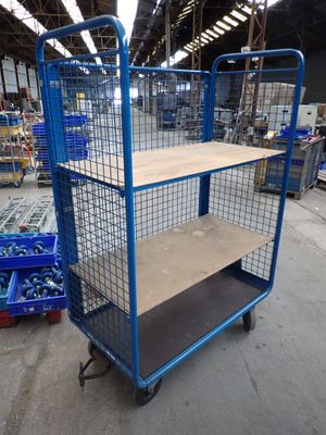 a blue cart with a shelf in the middle of a warehouse