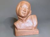 a small statue of a woman sitting on a table