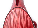 the back view of a red leather guitar case on a white surface