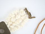 a cell phone and a necklace on a white table