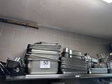 de nombreuses casseroles et poêles sur l'étagère de la cuisine