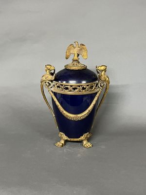 un vase bleu orné d'un motif doré sur le dessus