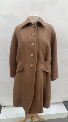 brown wool coat on a mannequin stand on a black and white checkered floor