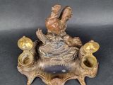 a bronze figurine of a bird sitting on a nest