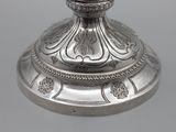 a silver candle holder with a clock on it