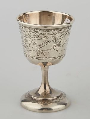 a silver goblet with a bird design on the rim