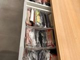 many bags of food in the drawer of a kitchen counter