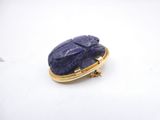 a close up of a blue stone broochle sitting on top of a white surface