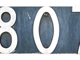 une plaque de numéro de maison bleue et blanche fixée au mur