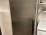 a stainless steel refrigerator in a kitchen with a washer and dryer