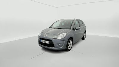 La petite voiture est garée dans une pièce blanche au sol blanc.