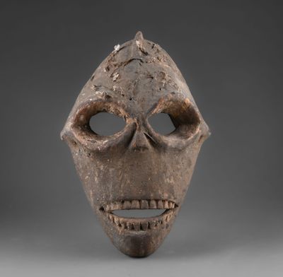 un gros plan d'un masque en bois représentant un visage