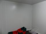 a small room with a white wall and a red chair