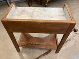 an old wooden table with a marble top and a glass top