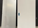 deux portes métalliques ornées d'un autocollant bleu, devant un mur noir