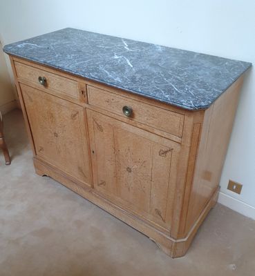 une armoire en bois avec un plateau en marbre, placée dans un coin de la pièce