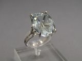 a close up of a ring with a large blue topaz stone