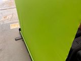 a green screen that is on the ground next to a suitcase
