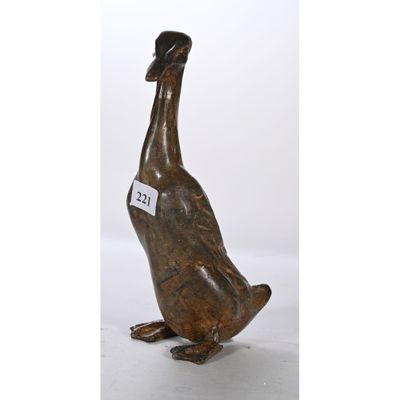 une photo d'une statue de canard en bronze avec une étiquette autour du cou