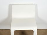 an image of a white plastic chair against a white wall