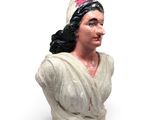 statue d'une femme en robe blanche, avec une fleur rose dans les cheveux