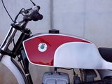 a red and white motorcycle parked in front of a wall