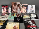 several books are arranged on a table in front of a gray background