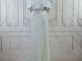 a white dress on a mannequin stand in a room