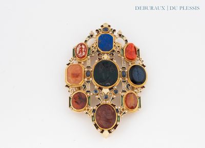 a gold brooch with multi colored stones on it