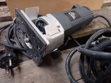 a picture of a corded electric tool on a wooden table