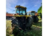 a couple of yellow tractors parked in a field next to each other