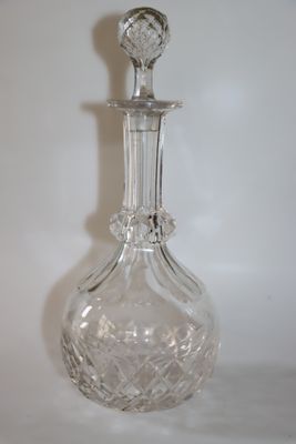 une carafe en verre transparent posée sur une surface blanche