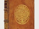 un vieux livre dont la couverture est ornée d'un motif doré