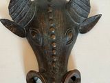 une tête de taureau en métal avec des cornes, accrochée au mur