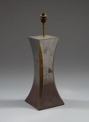 une photo d'une lampe en métal posée sur une table, sur fond blanc