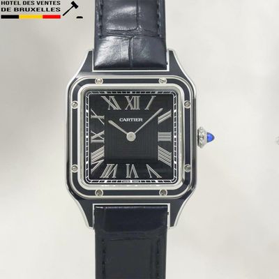 un gros plan d'une montre noire dont le cadran est orné de chiffres romains