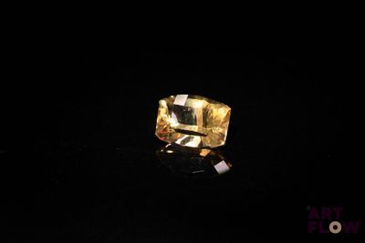 gros plan d'un diamant jaune sur une surface noire