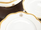 three plates with gold trims on them on a table