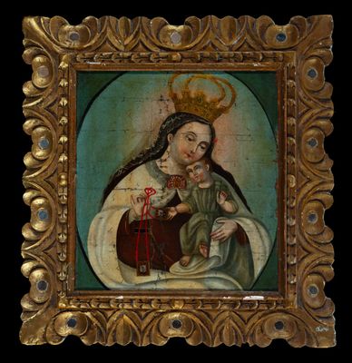 un vieux tableau représentant une femme tenant un enfant dans ses bras, dans un cadre doré