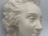 sculpture of a woman ' s head with braids on a white background