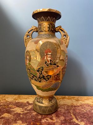 un vase avec un tableau posé sur une table