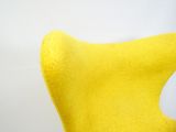 une chaise jaune posée sur une surface blanche