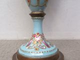 un vase bleu et or posé sur un socle au sol