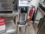une cafetière posée sur un support métallique dans une cuisine