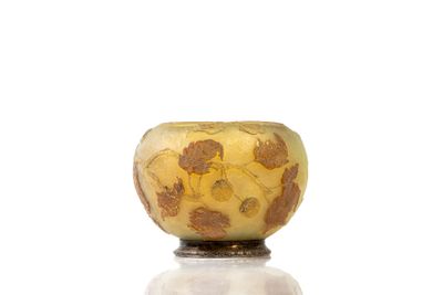 a yellow and brown vase sitting on top of a white table