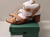 Il y a une paire de sandales posée sur la boîte à chaussures.